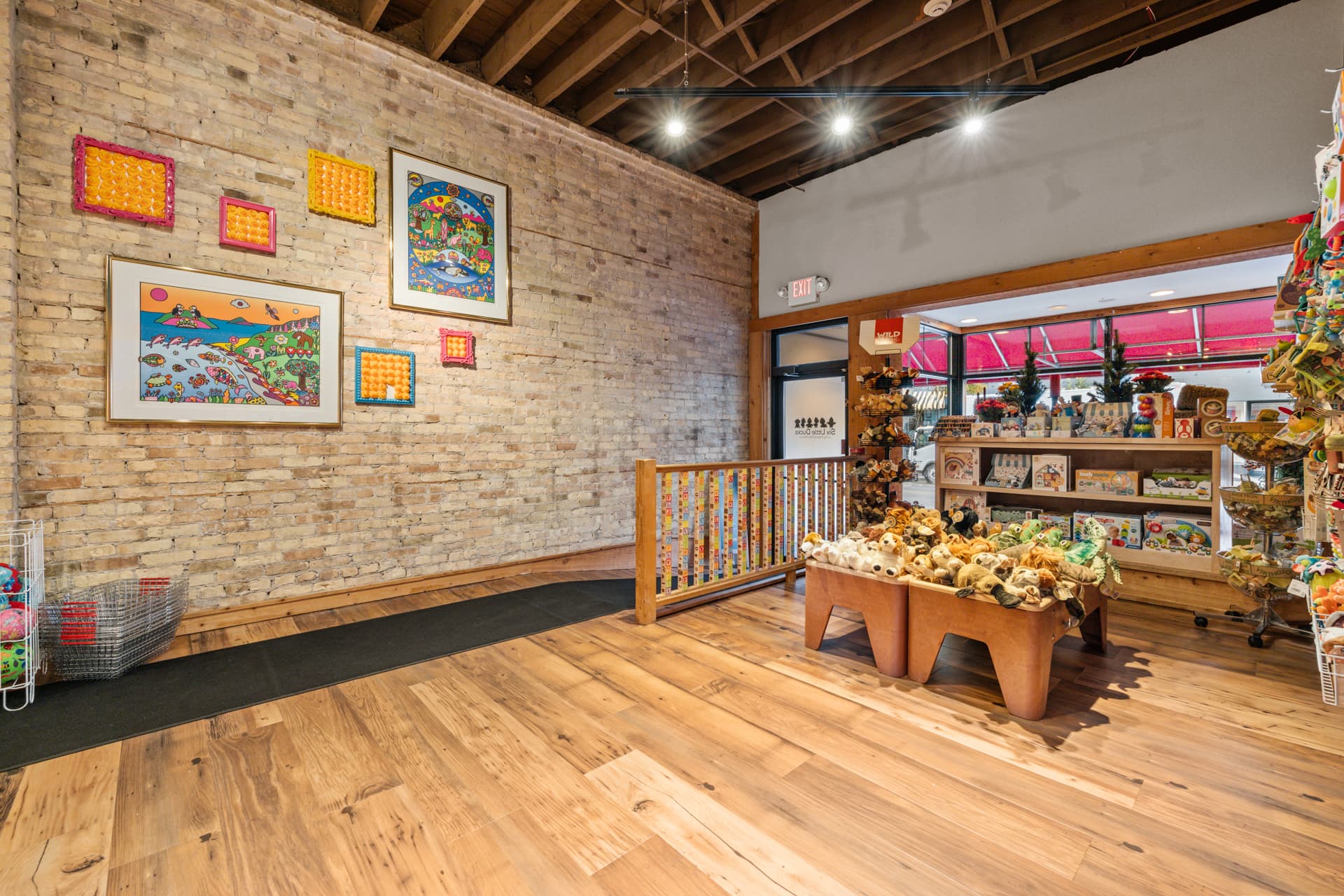 Plush animals and colorful wall art in the front room of the toy store